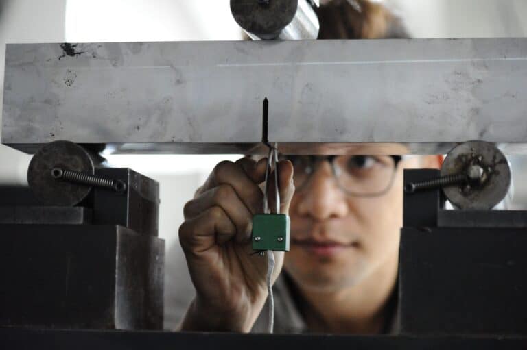 CTOD specimen with clip gauge in three-point bend rig for crack tip opening displacement test.