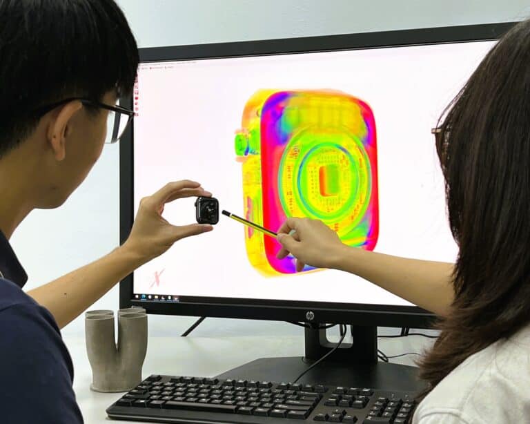 PTSPL technicians comparing a physical electronic component with its 3D CT reconstruction on screen.
